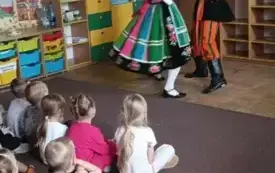 Pan z panią przebrani w stroje łowickie tańczą.