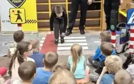 Dziecko pokazuje jak nie należy przechodzić przez ulicę.