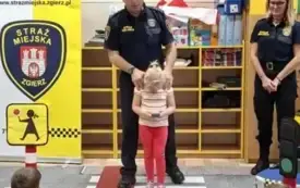 Dziecko pokazuje jak nie należy przechodzić przez ulicę.