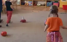 Dzieci biegną slalomem między dyniami