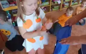 Dziewczynka trzyma w ręku marchewkę.