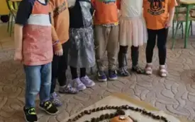 Dzieci stoją przy wykonanej mandali.