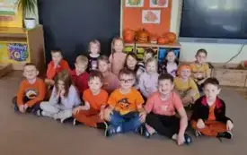 Dzieci siedzą ,uśmiechają się .