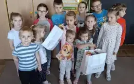 Dzieci stoją ,uśmiechają się .