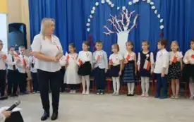 Pani Dyrektor stoi na środku sceny i przemawia