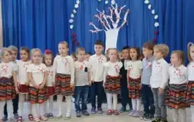Dzieci ubrane na ludowo stoją na scenie