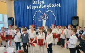 Dzieci ubrane na ludowo stoją na scenie
