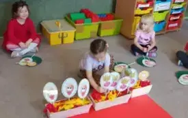 Dziewczynka wyjnmuje znaczek warzywa z doniczki