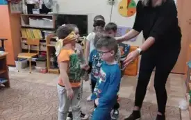 Pani psycholog prowadzi chłopca między pachołkami