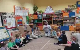Dzieci siedzą na dywanie.