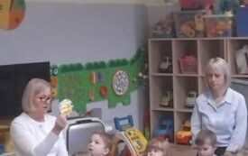 Nauczyciel pokazuje dzieciom kolorowy owoc