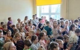 Dzieci siedzą ,uśmiechają się .