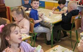 Dzieci malują farbami figurki ceramiczne