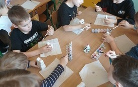 Dzieci malują figurki wielkanocne. 