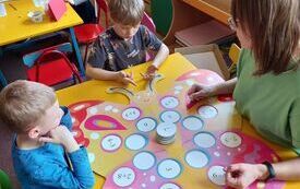 Dzieci rozwiązują działania matematyczne przy stoliku