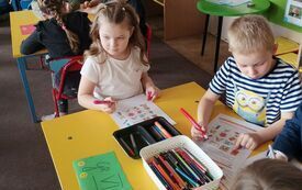 Dzieci rozwiązują zadania przy stoliku