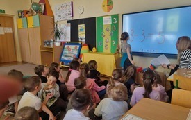 Dzieci rozwiązują działania matematyczne na tablicy multimedialnej.