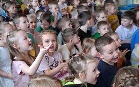 Dzieci śpiewają, siedzą na dywanie