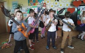 Chłopcy grają na dmuchanych gitarach