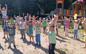 Dzieci uczestniczą w zabawie ruchowej przy muzyce