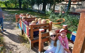 Dzieci siedzą na placu zabaw