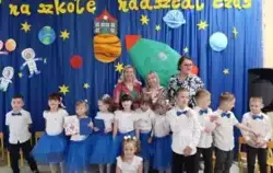 Dzieci stoją wraz z nauczycielami ,uśmiechają się .