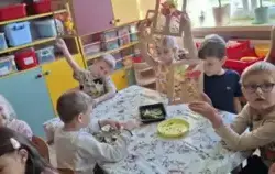 Dzieci pokazują wykonaną pracę plastyczną.