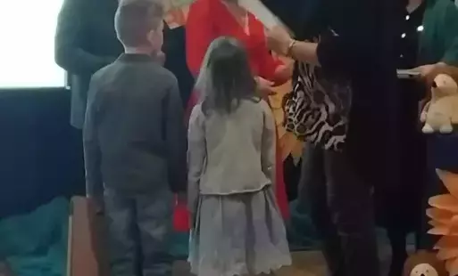 Nauczyciel wraz z dziećmi odbiera nagrodę . 