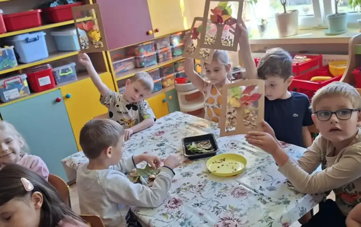 Dzieci pokazują wykonaną pracę plastyczną.