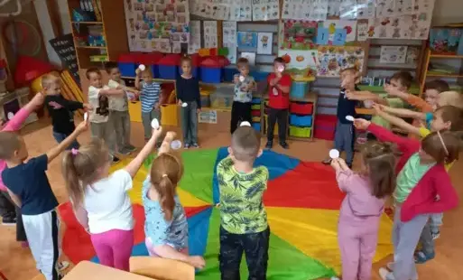 Dzieci stoją wokół chusty animacyjnej