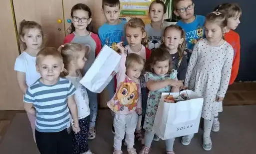 Dzieci stoją ,uśmiechają się .