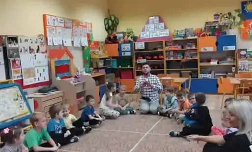 Dzieci siedzą w kole na dywanie