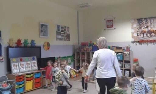Dzieci maszerują po klasie z znauczycielem