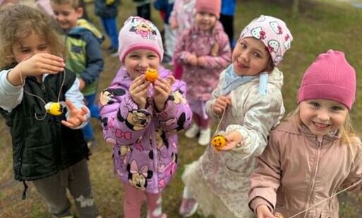 Dziewczynki pokazują pszczoły z plastikowych jajek
