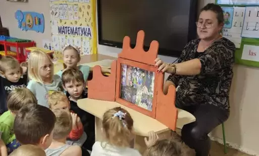 dzieci słuchają nauczycielki opowiadającej bajkę o "Jeżu ze Zgierza"
